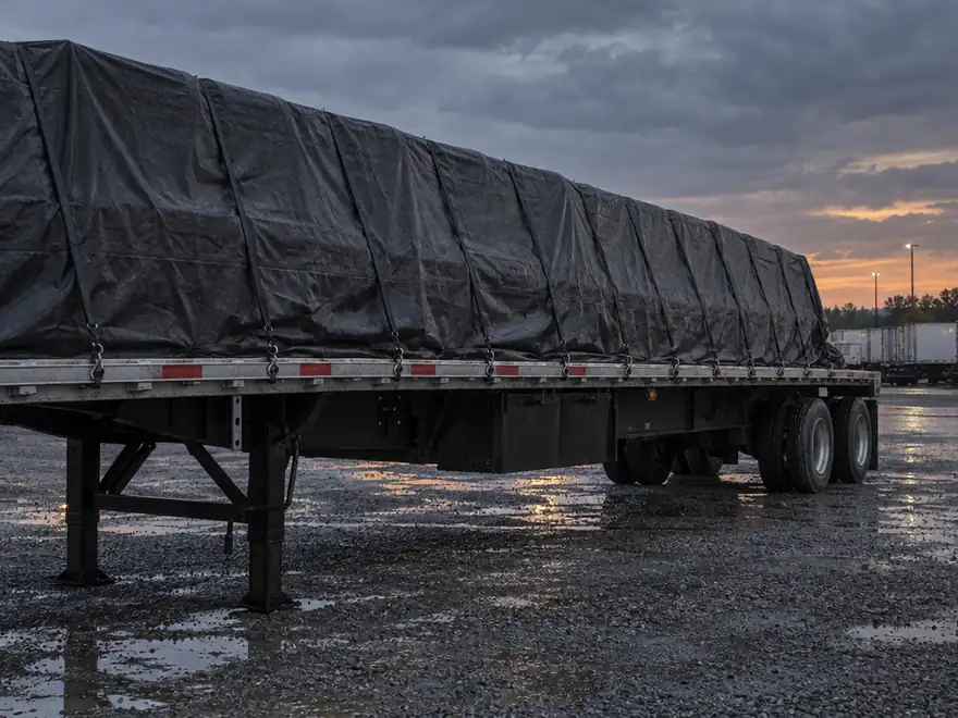Flatbed trailer load secured with rubber tarp straps